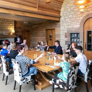people sitting round a table in an Anglo-Saxon style modern room eating and drinking